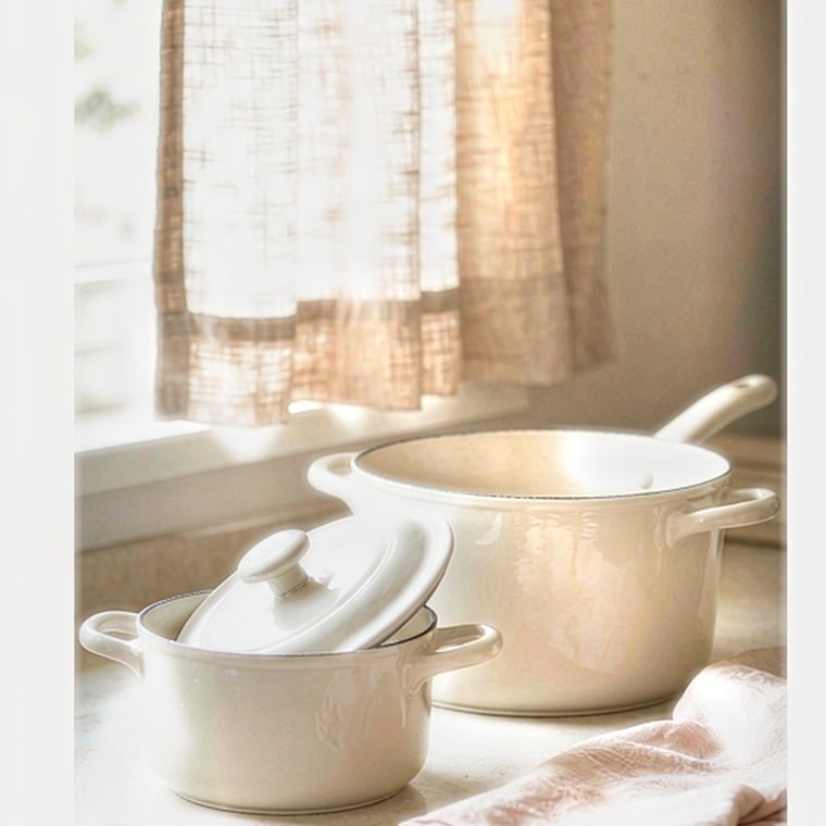 A bright kitchen counter with a Marholm cream cookware set